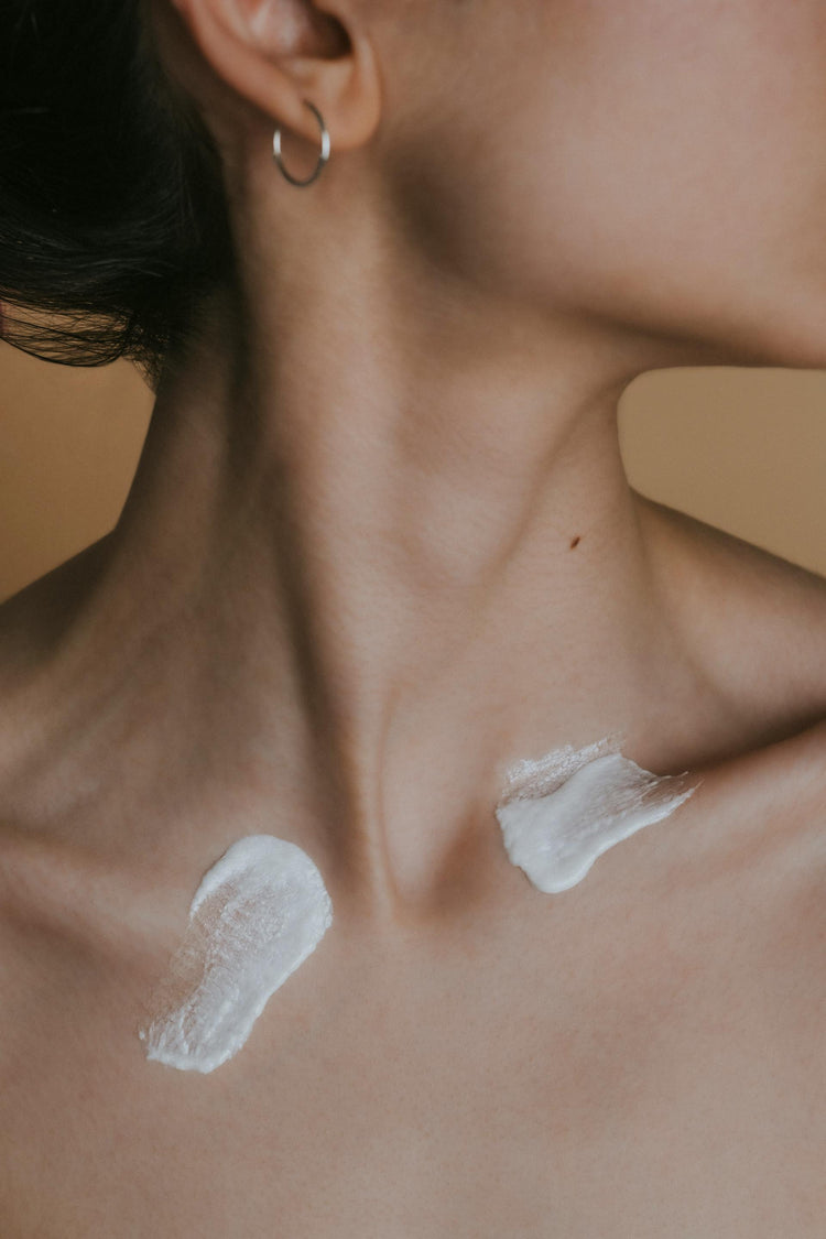 A women with CBD cream on her chest to help with skin car