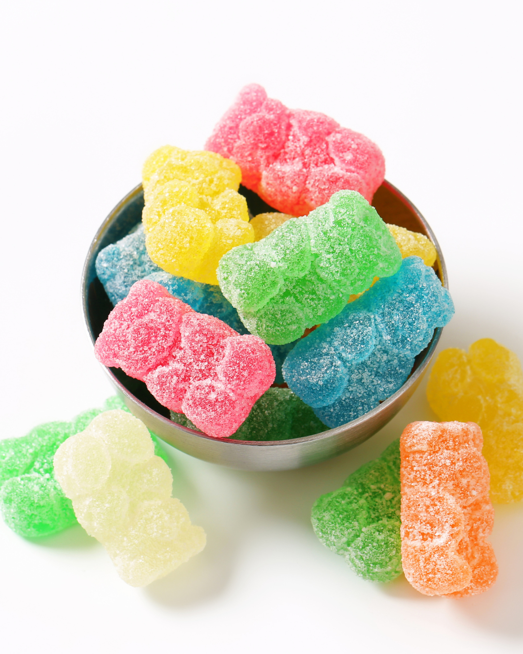 Colorful CBD gummy bears in a bowl on a white background